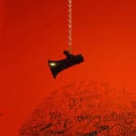 Hanging megaphone with graffiti and slogans on wall.