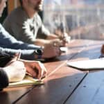 Group of professionals having a business meeting at a wooden table.